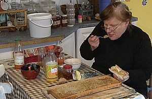 Dégustation de miel bio: Christine prend plaisir à consommer le miel de nos abeilles